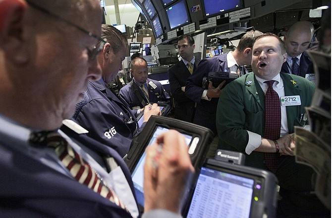 Specialist Michael Shearin, right, directs trades at his post on the floor of the New York Stock Exchange, Tuesday, April 27, 2010. (AP Photo/Richard Drew)