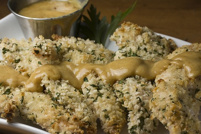 This photo taken Sept. 20, 2009 shows Parmesan-crusted Chicken Fingers. Keeping the oil low by &quot;oven-frying&quot; and including a tasty, low calorie dipping sauce will make everyone happy at the dinner table. (AP Photo/Larry Crowe)