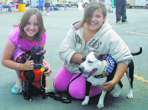 Sandi Hoover/Nevada AppealAbby Northrop, left, and Quincey Sosebee, both 10 and from Carson City, are all smiles during the Mutt Strut on Saturday. Abby rubs the ears of her puggle, Savannah, while Quincey hugs her Staffordshire terrier, Shortie.