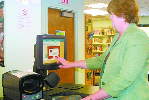 Sandi Hoover/Nevada AppealLibrary Director Sara Jones demonstrates the library&#039;s touch-screen self-checkout system. Upgrades to be installed during the next two weeks will include four additional checkout stations.