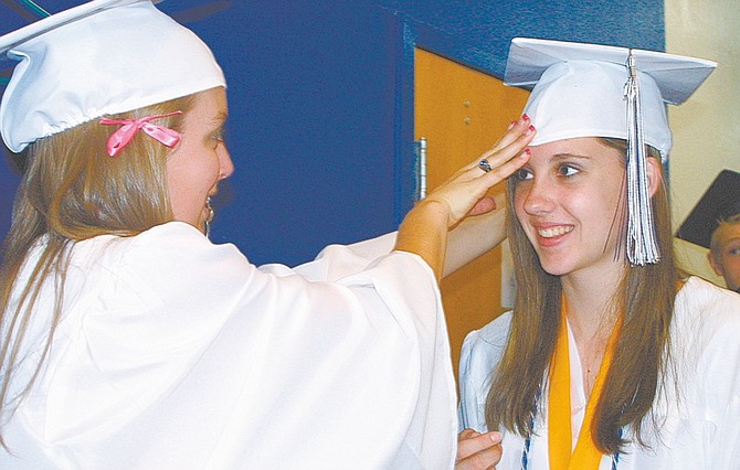 Sandi Hoover Nevada AppealKatelyn Defebaugh, 17, helps Virginia City High School salutatorian Mara Chapman, 16, adjust her cap.