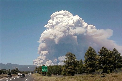 A new wildfire burns at Shultz Pass between the San Francisco Peaks and Mount Elden Sunday, June 20, 2010, in Flagstaff, Ariz. The Timberline neighborhood is being evacuated and two other neighborhoods nearby are on standby.  (AP Photo/Michele Legg)