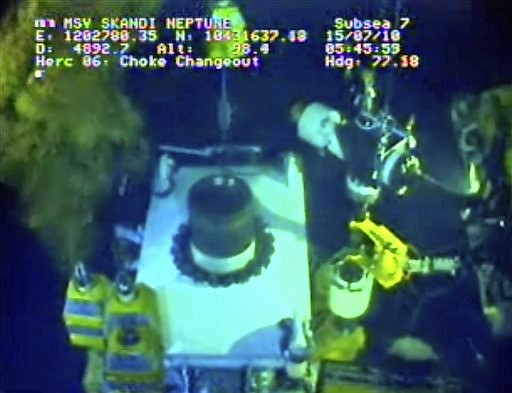 In this image taken from video provided by BP PLC at 6:45 a.m. EDT Thursday July 15, 2010, oil flows from one of three valves of the new 75-ton cap atop the site of the Deepwater Horizon oil spill in the Gulf of Mexico as testing continues Thursday. BP engineers working to choke the flow of oil into the Gulf of Mexico found a leak on a line attached to the side of the new well cap and were trying to fix it Thursday before attempting to stop the crude. (AP Photo/BP PLC) NO SALES