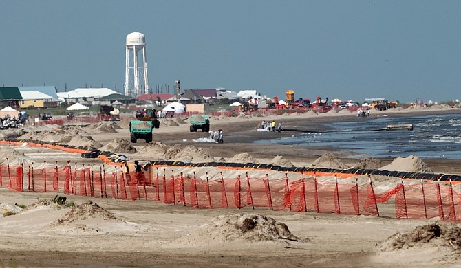 Oil cleanup workers continue their efforts on the beach in Grand Isle, La., Monday, July 19, 2010. Oil from the Deepwater Horizon incident continues to wash ashore on Grand Isle. (AP Photo/Dave Martin)