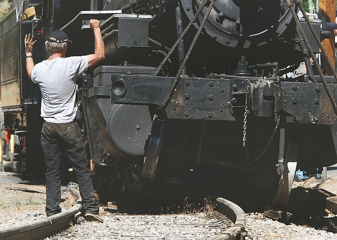 Jim Grant / Nevada Appeal  A worker provides hand signals to a crane operator lifting the Virginia and Truckee Engine No. 29 back onto the track Monday morning. The engine derailed on Sunday evening with seven passengers on board. No one was injured.