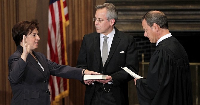 Elena Kagan is sworn in as the Supreme Court&#039;s newest member as Chief Justice John Roberts, right, administers the judicial oath, at the Supreme Court Building in Washington, Saturday, Aug. 7, 2010. The Bible is held by Jeffrey Minear, center, counselor to the chief justice. Kagan, 50, who replaces retired Justice John Paul Stevens, becomes the fourth woman to sit on the high court and is the first Supreme Court justice in nearly four decades with no previous experience as a judge. (AP Photo/J. Scott Applewhite)