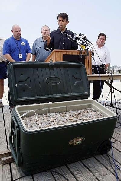 Louisiana Gov. Bobby Jindal, center, speaks at a press conference held to address the reopening of commercial fishing areas along the Louisiana coast behind a chest of shrimp caught this morning in Dixon Bay in Venice, La., Monday, Aug. 2, 2010. Standing behind Jindal are St. Bernard Parish president Craig Taffaro, left, Louisiana Wildlife and Fisheries secretary Robert Barham and Plaquemines Parish president Billy Nungesser. (AP Photo/Patrick Semansky)