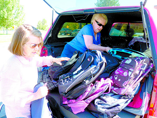 Teri Vance/Nevada AppealDixie Busch, left, hands backpacks to Pat Riggs on Monday at Carson High School. The Soroptimist International members helped organize a drive to collect more than 300 backpacks.