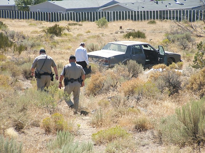 F.T. NortonLyon County deputies walk down to a vehicle that stopped in a ditch after a minor traffic accident in Mound House this morning. The driver was pronounced dead at the scene, possibly from a preexisting medical condition.