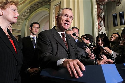 Senate Majority Leader Harry Reid, D-Nev., speaks with reporters after the Senate cleared a hurdle to restore unemployment benefits to millions of Americans who have been out of work for more than six months, at the Capitol in Washington, Tuesday, July 20, 2010. The 60-40 vote came moments after Sen. Carte Goodwin, D-W.Va., behind Reid at left, was sworn in as the appointed successor to West Virginia Democrat Robert Byrd. (AP Photo/J. Scott Applewhite)