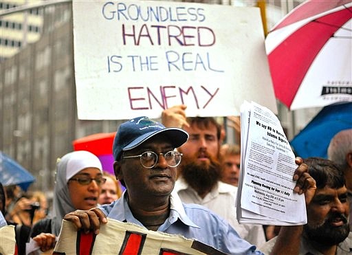 Demonstrators in favor of the proposed Islamic center near ground zero make their feelings about the emotionally charged subject known on Church Avenue in lower Manhattan, Sunday, Aug. 22, 2010. Opponents and supporters of the Islamic cultural center were separated by barricades and police officers as both groups demonstrated near the proposed site. (AP Photo/Swoan Parker)