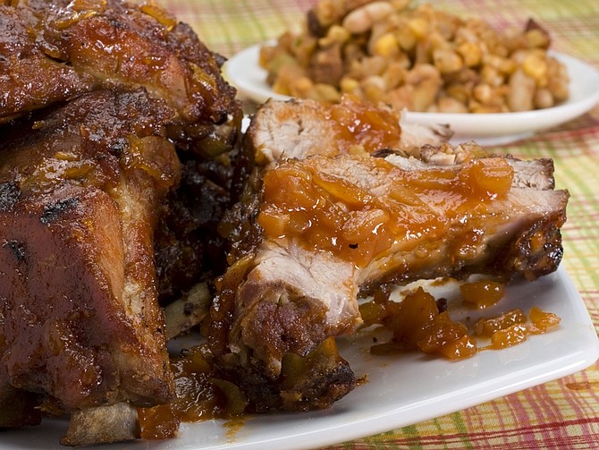 Falling-off-the-bone barbecued ribs with chili-ale sauce are seen in this June 7, 2010 photo. These ribs are started with a par boiling then finished up by indirect heat on the grill. (AP Photo/Larry Crowe)