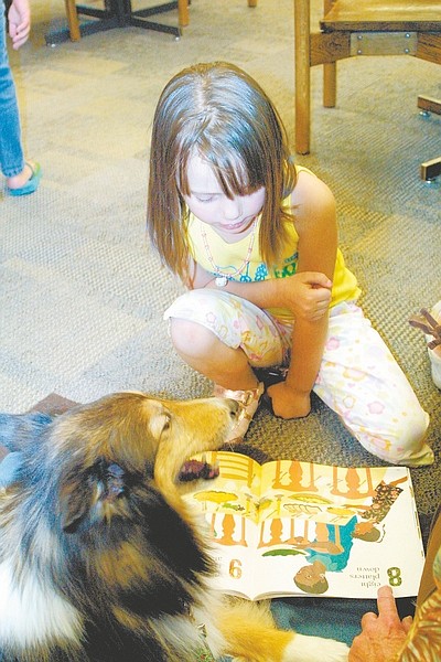 Photos by Sandi Hoover/Nevada AppealSavanna Spain, 5, reads to Isabella Saturday during the Carson City Library&#039;s Love on a Leash program.