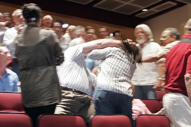 An unidentified man punches Kay Mehta  after a Senate candidate forum for Angle and Reid at Faith Lutheran High School Thursday, Sept. 23, 2010 in Las Vegas.   The fight came after an impassioned event during which the crowd both heckled and cheered Republican Sharron Angle and Democrat Harry Reid. (AP Photo/Las Vegas Sun, Sam Morris)