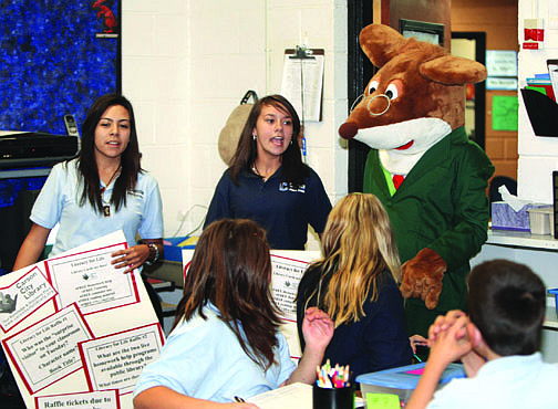 Jim Grant/Nevada AppealCarson Middle School students Alyssa Lopez, left, and Ashley Lyford escort Amber Sady dressed as children&#039;s book character Geronimo Stilton to class rooms on Tuesday morning and announce that all students will receive public library cards.