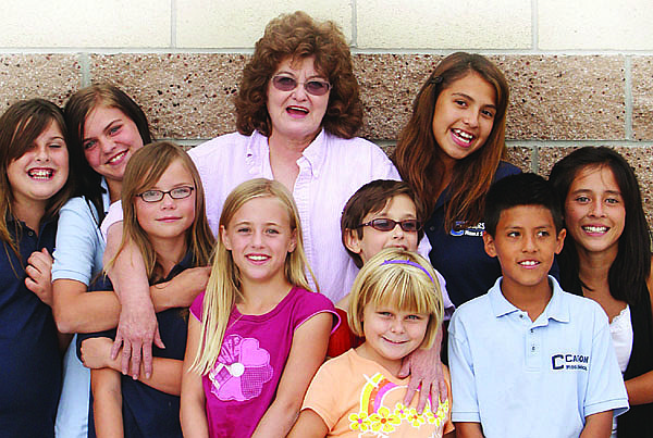 Jim Grant/Nevada AppealMaria O&#039;Neill, a volunteer at the Boys and Girls Club, poses with members outside the club. She teaches sewing skills there.