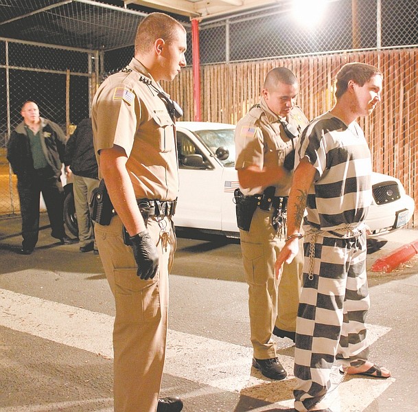 F.T. Norton/Nevada Appeal As Lyon County Sheriff&#039;s Deputy Peter Whitten looks on, Deputy Herbert Parada checks James Masterson, 22, before he is booked into the Lyon County Jail in Yerington on Tuesday night. Lt. Brian Veil can be seen in the background. RIGHT: Deputy Parada removes ankle cuffs from Masterson inside the Lyon County Jail.
