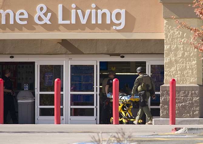 Officers wheel a gurney into the store during a standoff following a shooting at a Reno Walmart Friday, Oct. 29, 2010. The shooter, a Walmart employee, has been identified as John Dennis Gillane, 45-years of age. One of the three shooting victims was a store manager . (AP Photo/Scott Sady)