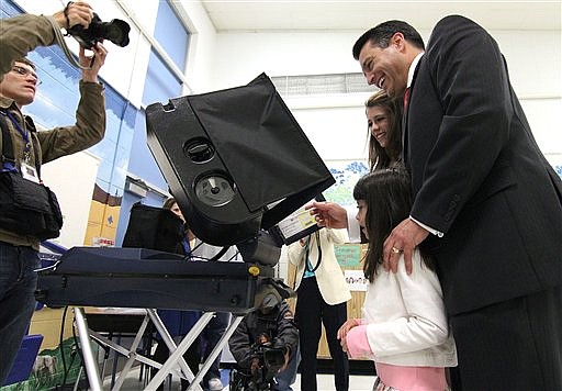 Republican gubernatorial candidate Brian Sandoval votes at Roy Gomm Elementary School on Tuesday, Nov. 2, 2010 in Reno, Nev., with daughters Marisa and Maddy (AP Photo/Cathleen Allison)