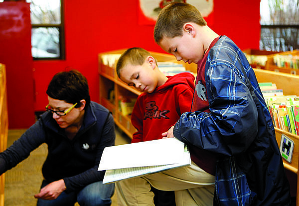 Shannon Litz/Nevada AppealBrothers Chance Kaamasee, 6, and Zachary Forbis, 8, look at a book at the Carson City Library on Saturday while library assistant Kate Kolodziej helps them find other books about dogs. Zachary, a second-grader at Bordewich-Bray Elementary, recently got a library card at school.