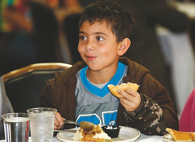 Photos by Shannon Litz/Nevada AppealEight-year-old Mac Hensley eats his Thanksgiving dinner at the Carson Nugget on Thursday.