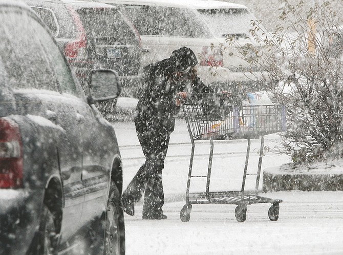 Jim Grant/Nevada AppealA Raley&#039;s shopper walks to her vehicle on a snowy Tuesday morning.