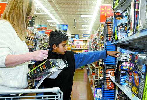 Shannon Litz/Nevada AppealShelly Cohen helps 11-year-old Oswaldo Mata choose a helicopter toy at Walmart on Saturday morning.