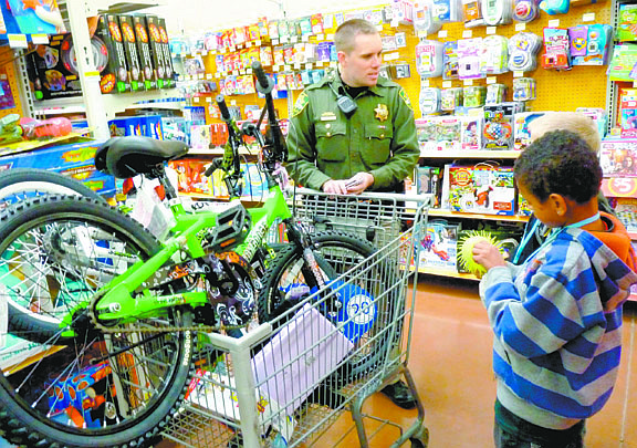 Photos by F.T. Norton/Nevada AppealReserve Deputy Chris McMahon shops with students during the Holiday with a Hero shopping spree at the Carson City Walmart on Thursday.
