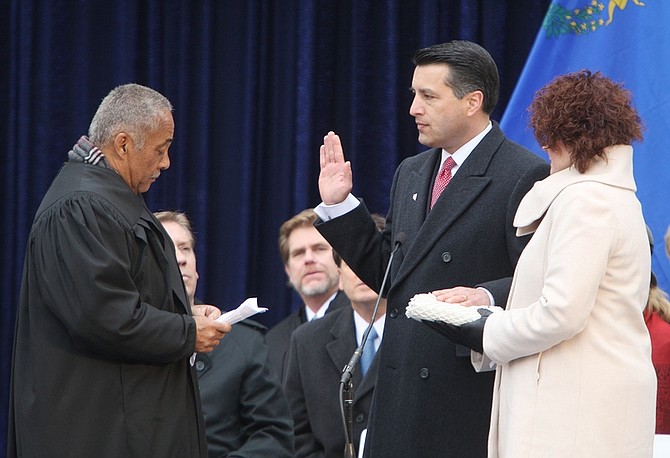 Jim Grant/Nevada AppealNevada Supreme Court Chief Justice Michael Douglas, left, gives Gov. Brian Sandoval the oath of office on Monday.