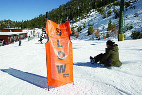 Adam Jensen/Nevada Appeal News ServiceA woman uses her snowboard as a sled to slide past a &quot;slow&quot; sign at Heavenly Mountain Resort.