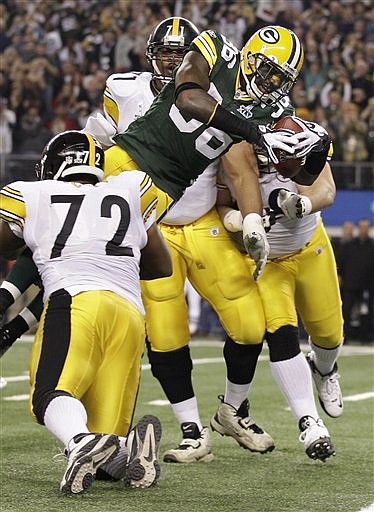 Green Bay Packers&#039; Nick Collins dives past Pittsburgh Steelers&#039; Flozell Adams (71) and Jonathan Scott (72) for a touchdown after intercepting a pass by Pittsburgh Steelers Ben Roethlisberger during the first half of the NFL football Super Bowl XLV Sunday, Feb. 6, 2011, in Arlington, Texas. (AP Photo/Chris O&#039;Meara)