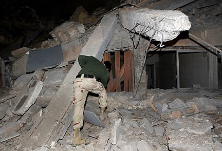Associated PressA Libyan soldier surveys the damage to an administrative building hit by a missile late Sunday, March 20, 2011 in the heart of Moammar Gadhafi&#039;s Bab Al Azizia compound in Tripoli, Libya, as he is pictured during an organized trip by the Libyan authorities. No casualties were reported.
