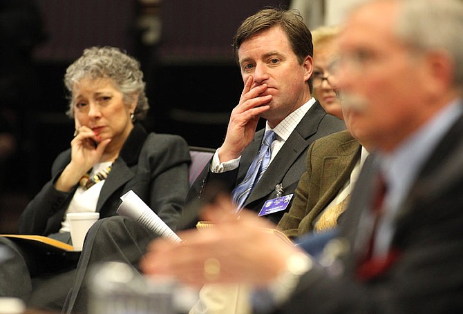 Nevada Assemblywoman Peggy Pierce, D-Las Vegas, left, and mining lobbyist Tim Crowley, center, listen to testimony against Pierce&#039;s proposal to retool a mining tax formula during a hearing on Thursday, April 7, 2011, at the Legislature in Carson City, Nev. Crowley also testified against the bill saying the industry supports a broad-based business tax, not one that singles out just the mining industry. (AP Photo/Cathleen Allison)