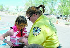 Courtesy Lyon County Search and RescueA Lyon County Search and Rescue volunteer fits a child with a safety vest during last year&#039;s Project Life Vest: Save a Child&#039;s Life at Lake Lahontan.