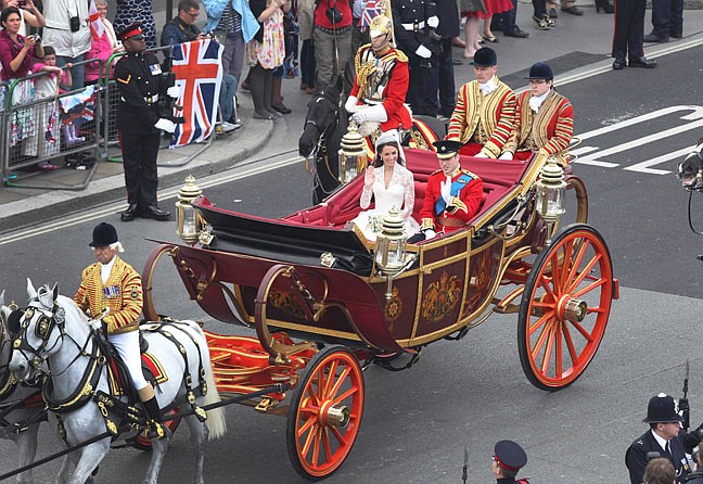 Britain&#039;s Prince William and and his wife Kate, the Duchess of Cambridge travel to Buckingham Palace in a 1902 State Landau carriage after their wedding at Westminster Abbey, London, Friday, April 29, 2011. (AP Photo/Peter Jordan, Pool)