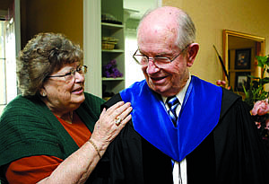 Shannon Litz/Nevada AppealNaomi Karr helps her husband, Don, with his graduation hood on Friday at home in Carson City.