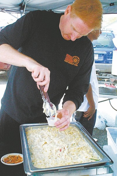 Nevada Appeal File PhotoTom Van Ardoy from Pioneer Crossing serves up an Italian noodle dish - southern fettuccini alfredo with blackened New York steak - for those who lined up with their taste tickets during the 9th annual Oodles of Noodles Cookoff last year in Dayton.
