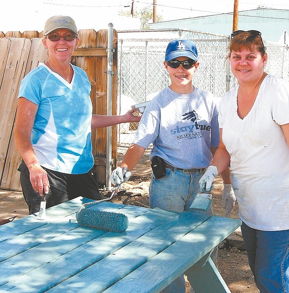 Published Caption: Carson City Leadership Class 2010 class project coordinator Margie Quirk, left, assists Noah Jennings and his mother, Stacy Woodbury, with the painting of one of the tables at the animal shelter.