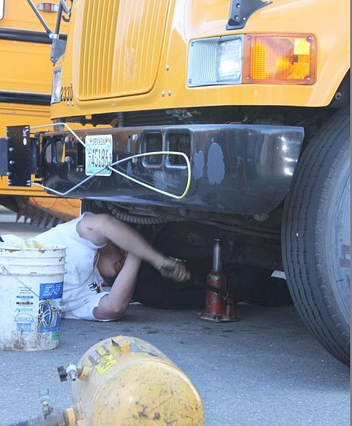 F.T. NortonAn employee of Les Schwab tires jacks up one of the 44 buses in the Carson City School District&#039;s fleet that had the tires flattened overnight.
