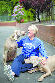 ** ADVANCE FOR USE AT 12:01 A.M EST MONDAY, MAY 23, 2011 AND THEREAFTER ** In this Friday, May 13, 2011 picture, Karen Cornwall plays with her dogs Bel, left, and Mac, in front of her home in Havertown Pa. Cornwall, a nurse who played a slew of sports since childhood, had both knees replaced last year when she was 54. Dr. Nicholas DiNubile, an adviser to several pro athletic groups and a spokesman for the American Academy of Orthopaedic Surgeons, says &quot;The boomers are the first generation trying to stay active in droves on an aging frame&quot; and are less willing to use a cane or put up with pain or stiffness as their grandparents did. (AP Photo/Matt Rourke)
