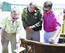 Shannon Litz/Nevada AppealCarson City Mayor Bob Crowell, Sheriff Kenny Furlong and Parks and Recreation Director Roger Moellendorf examine the identification ticket on a 1,600-pound I-beam which was delivered to Carson City Wednesday from the New York Port Authority from the World Trade Center Archives. Resident Jim Shirk arranged for the city to acquire the piece of steel which will be used in a monument to the memory of those who lost their lives on 9/11.