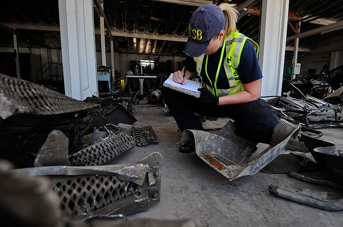 Jennifer Morrison, investigator for the National Transportation Safety Board (NTSB), works with the wreckage of the 2008 Peterbilt 367 truck-tractor at the Nevada Department of Transportation maintenance facility (NDOT) on Monday, June 27, 2011 in Fallon, Nev. The truck crashed into an Amtrak passenger car on June 24, 2011.  (AP Photo/Kevin Clifford).