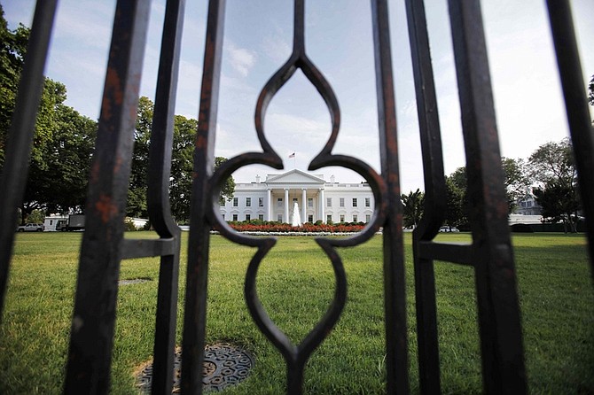 The White House is seen through the fence from Pennsylvania Avenue as debt talks continue in Washington, on Sunday, July 24, 2011. (AP Photo/Jacquelyn Martin)