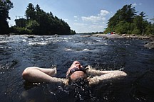 James Maxim of Lunenburg, Mass., soaks in the cooling water of the Saco River in Limington, Maine, Friday, July 22, 2011. The National Weather Service says the temperature hit 95 degrees as of noon Friday in Portland, breaking the old record of the date of 94 degrees set in 1994. (AP Photo/Robert F. Bukaty)