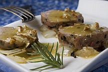 This photo taken Nov. 22, 2009 shows a pork tenderloin. A brown sugar and spice rubbed pork tenderloin, served over roasted onions, is perfect for a holiday buffet. While the recipe calls for brining, you can save time by using the dry rub only and serve topped with a simple vinaigrette. (AP Photo/Larry Crowe)