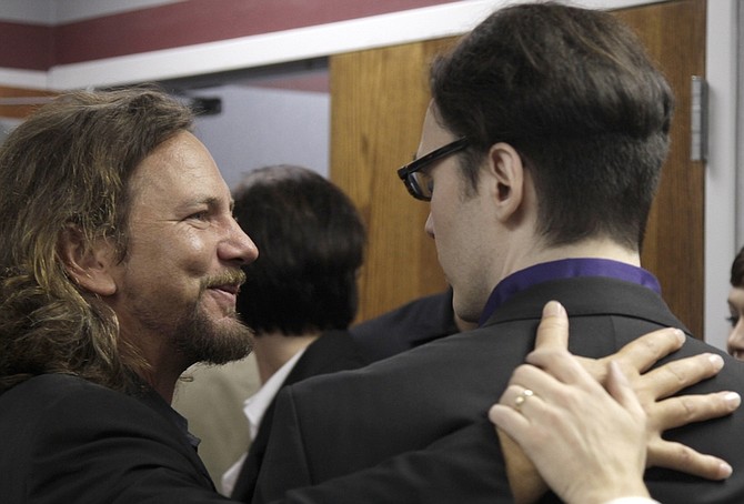 Eddie Vedder of the rock band Pearl Jam, left, embraces Damien Echols, one of three men released Friday, Aug. 19, 2011, at the Craighead County Court House in Jonesboro, Ark., after pleading guilty to crimes they say they did not commit. The three men, convicted of killing three 8-year-old Cub Scouts and dumping their bodies in an Arkansas ditch in 1993, were freed from nearly two decades in prison Friday, after they agreed to plead guilty to secure the release Echols from death row. Vedder became a key supporter of the men after watching a pair of documentaries about the case. (AP Photo/Danny Johnston)