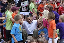 After posing for a photo summer school kids help President Barack Obama to his feet, Monday, Aug. 15, 2011, in Chatfield, Minn., outside the George H. Potter Audirorium during his three-day economic bus tour.  (AP Photo/Carolyn Kaster)