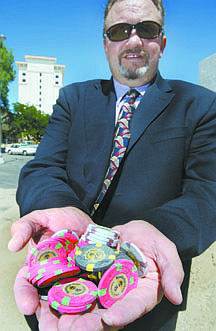 Jim Grant/Nevada AppealCarson City resident Roger Baugh holds a handful of the dozens of casino chips from the Carson City Travelodge that he found buried in a pile of sand that was excavated from the Ormsby House property last week.