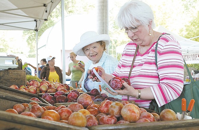 Shannon Litz / Nevada AppealRuth Benischek and Ali Vitrano, both of Carson City, shop at the Schletewitz Family Farms booth at the Mills Park farmers market on Wednesday afternoon.