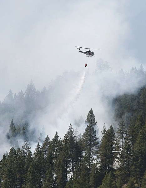 Shannon Litz/Nevada AppealA helicopter makes a pass over a wildfire currently burning   in the vicinity of Old Clear Creek Road